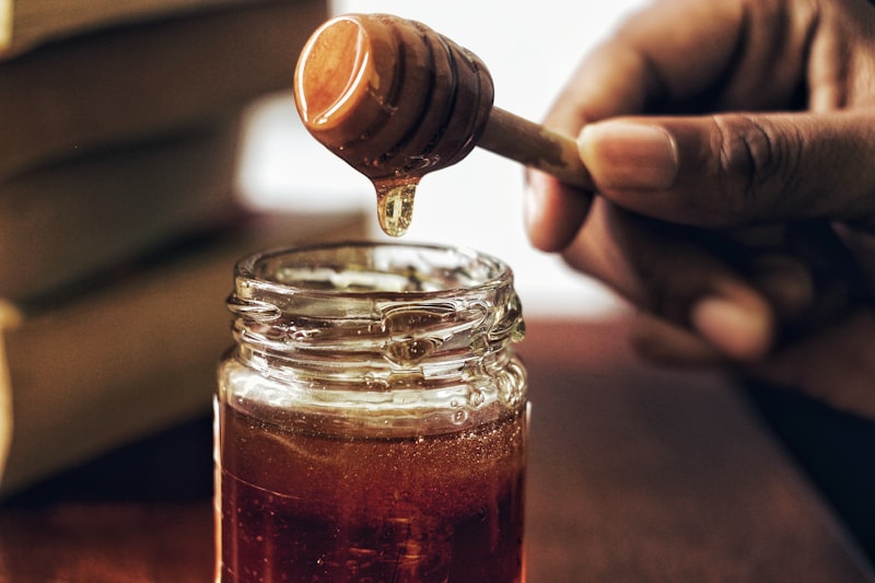 Glass jar of honey with honeycomb