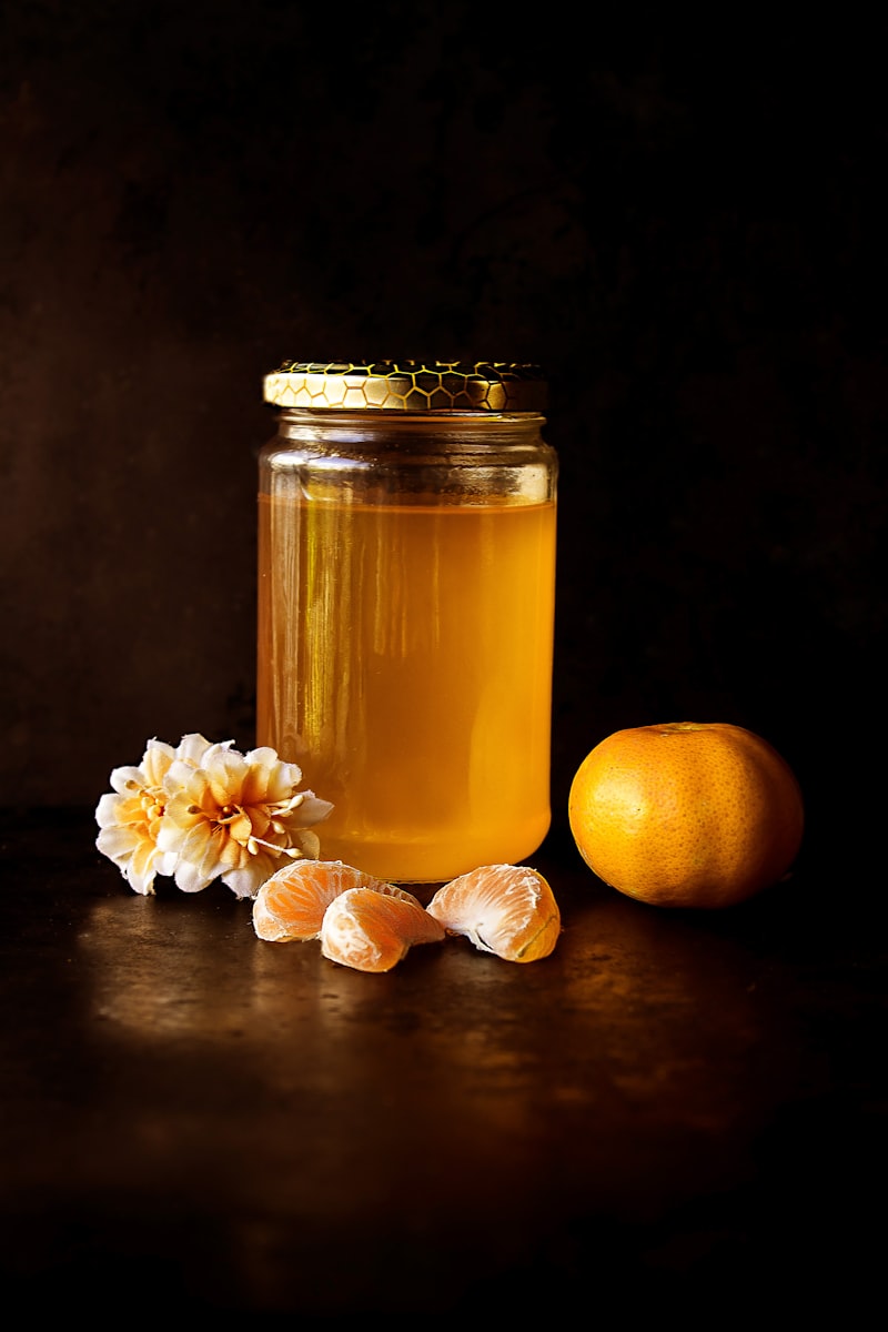 Glass jar of honey against a dark background